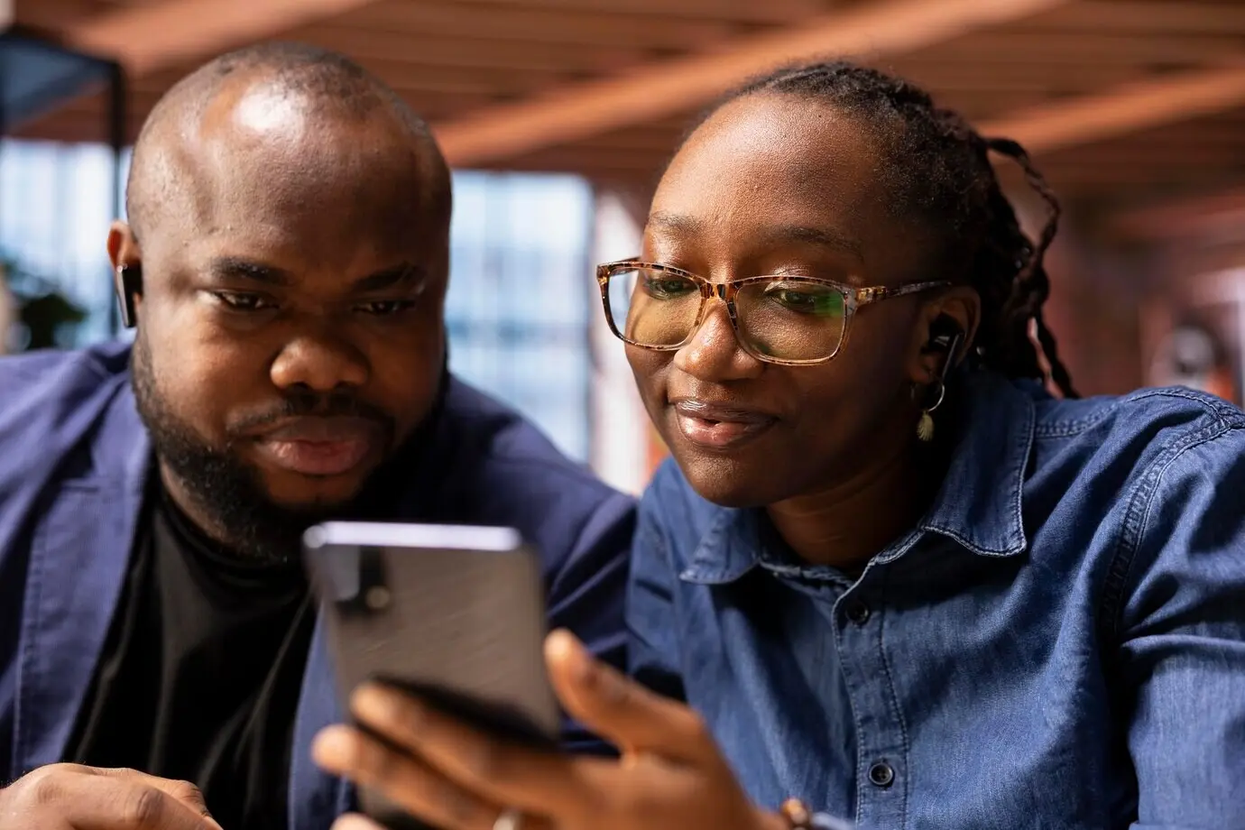Selbstbewusstes schwarzes Paar, das Kollegen während einer Diskussion per Videokonferenz begrüßt.