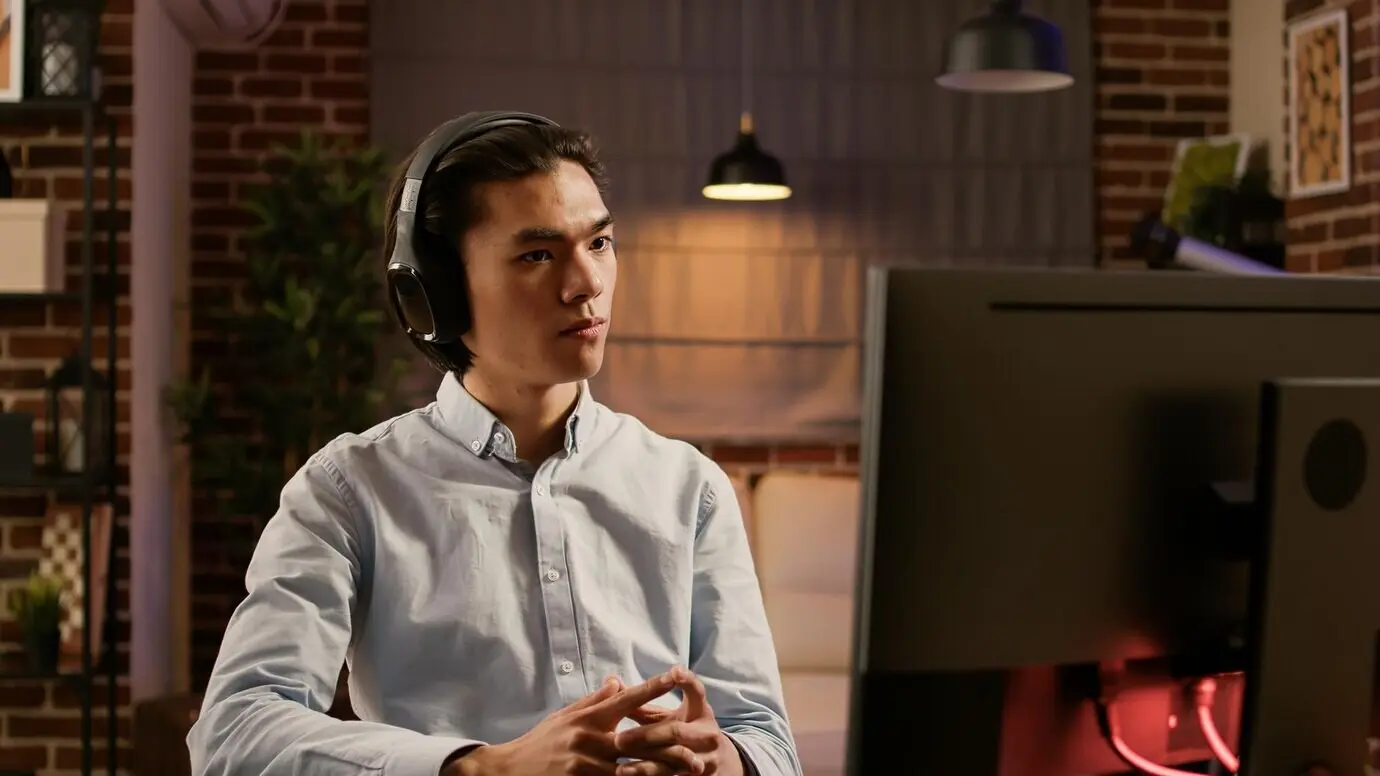 Mitarbeiter eines Unternehmens hört eine Podcast-Episode oder ein Webinar und nutzt den Computer, um aus der Ferne für ein Startup-Unternehmen zu arbeiten. Schulungsvortrag, um den Arbeitsbericht in einer Online-Anwendung zu lernen.