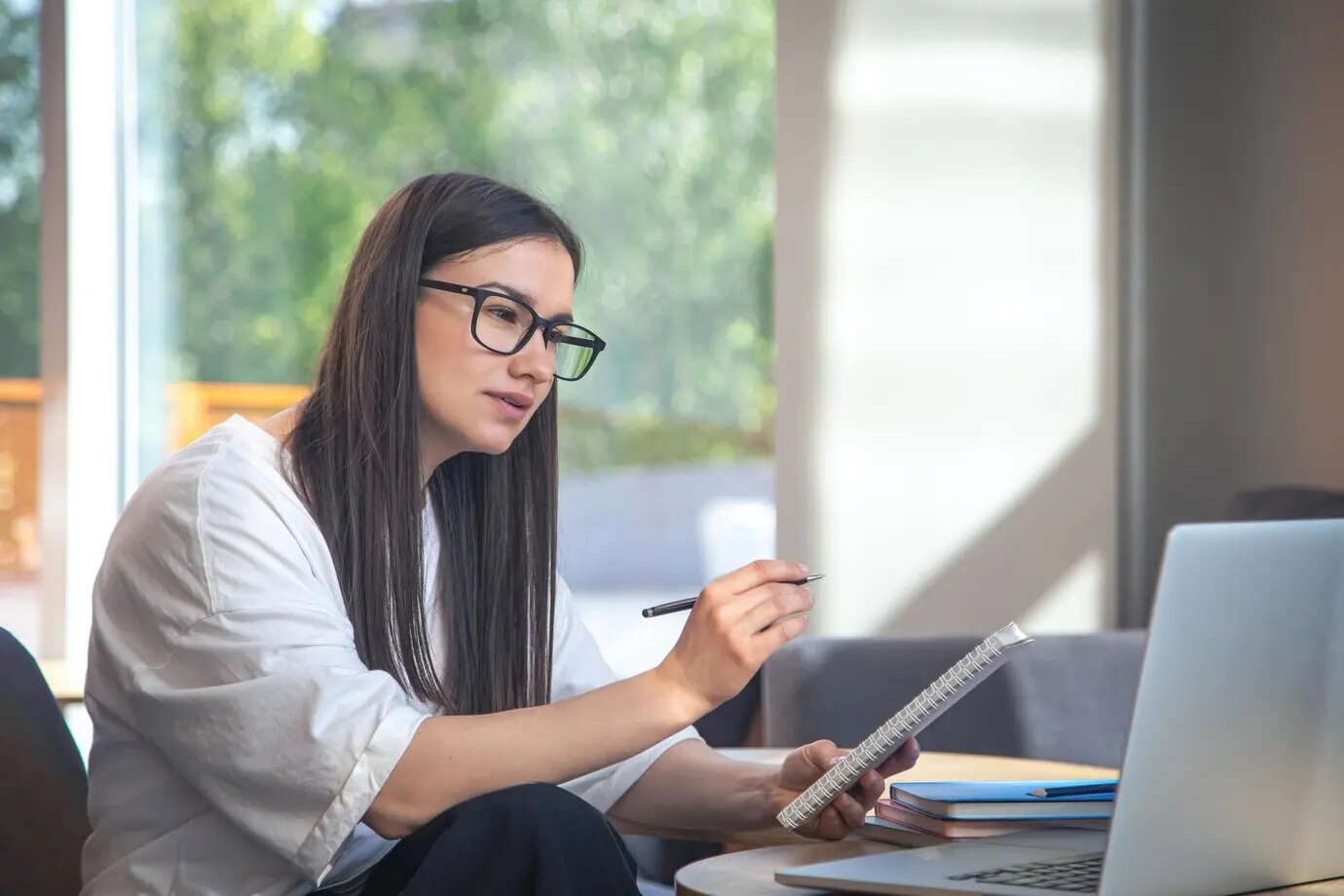 Eine junge Frau sitzt vor einem Laptop und lernt aus der Ferne.